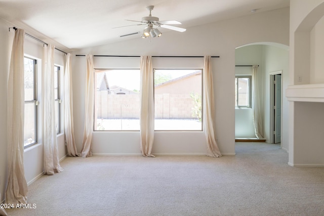 empty room with ceiling fan, light colored carpet, and lofted ceiling