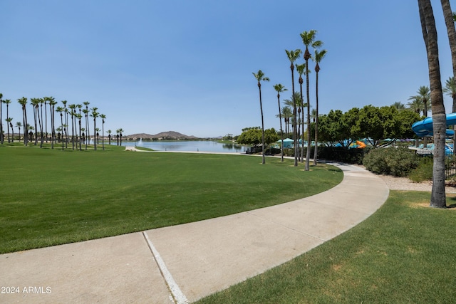 surrounding community featuring a water view and a lawn