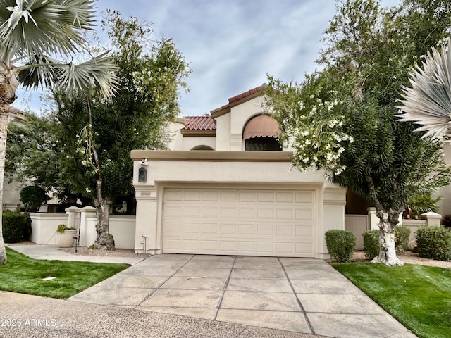 mediterranean / spanish-style house with a tiled roof, fence, concrete driveway, and stucco siding