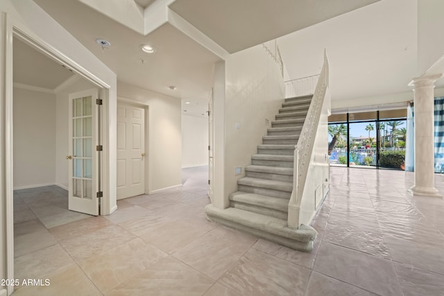 stairs featuring ornate columns, baseboards, and recessed lighting