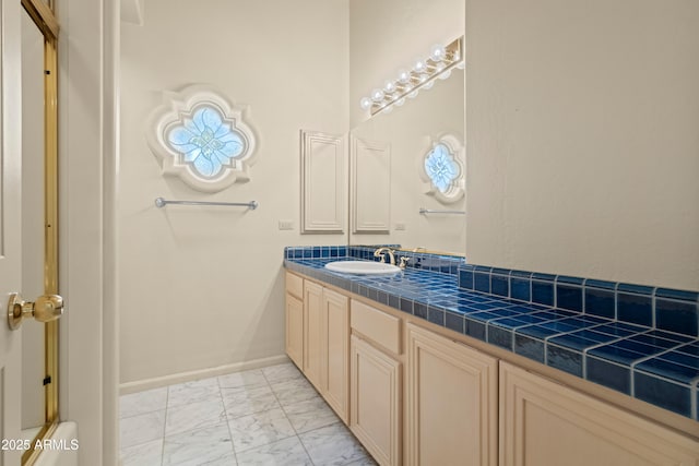 bathroom featuring marble finish floor, vanity, and baseboards