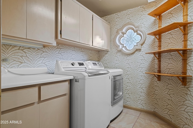 laundry room featuring wallpapered walls, light tile patterned floors, washer and dryer, and cabinet space