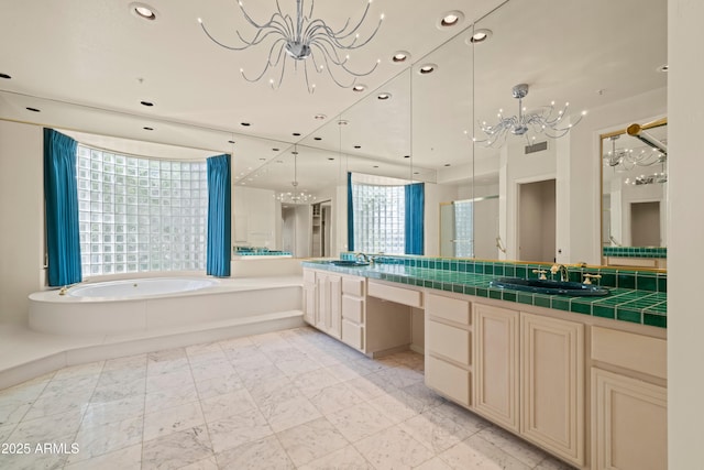 full bathroom featuring recessed lighting, a notable chandelier, vanity, and a bath