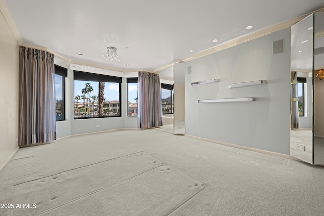 carpeted empty room with visible vents, ornamental molding, and baseboards