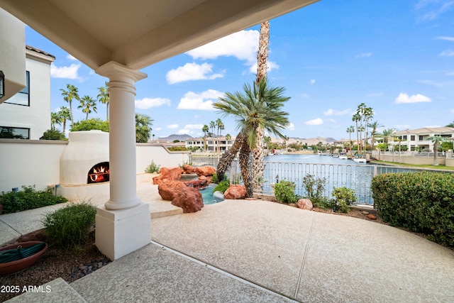 view of patio / terrace featuring a water view and a multi sided fireplace