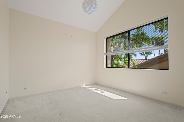 carpeted empty room with lofted ceiling and baseboards