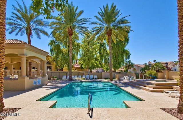 community pool featuring a patio and fence