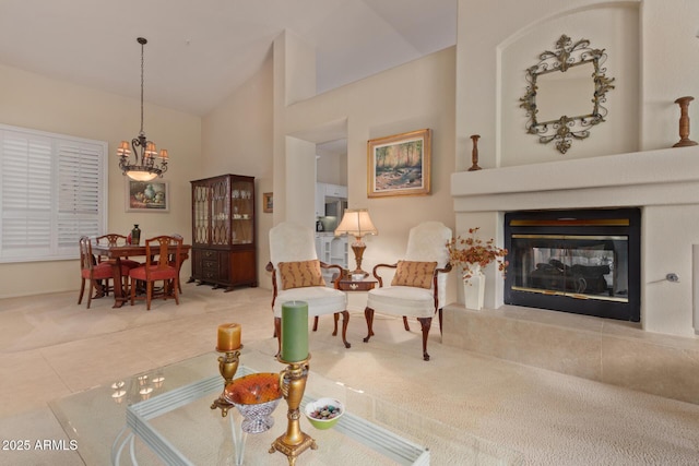 living area with high vaulted ceiling, tile patterned flooring, a chandelier, and a tiled fireplace