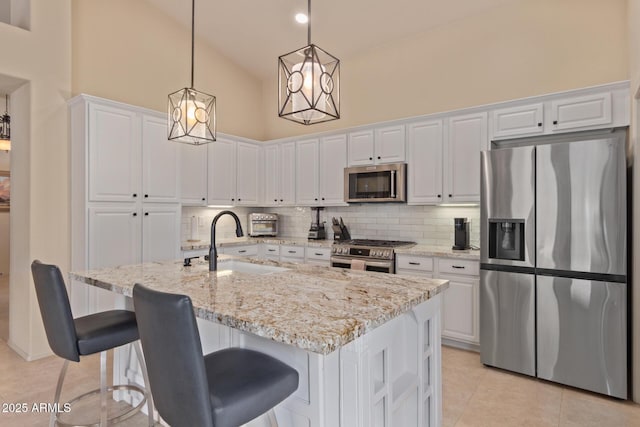 kitchen featuring tasteful backsplash, appliances with stainless steel finishes, white cabinetry, a sink, and light tile patterned flooring