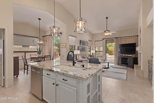 kitchen with dishwasher, open floor plan, a sink, and light tile patterned flooring