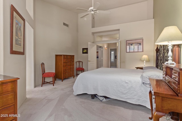 bedroom featuring light carpet, high vaulted ceiling, visible vents, and a ceiling fan