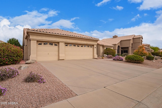 mediterranean / spanish-style house with a tile roof, driveway, an attached garage, and stucco siding