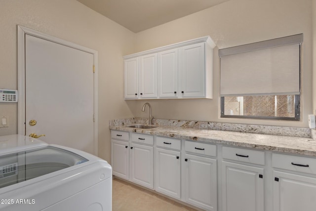 washroom featuring washer / clothes dryer, a sink, and cabinet space