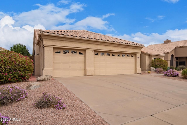 mediterranean / spanish-style home with concrete driveway, a tiled roof, an attached garage, and stucco siding