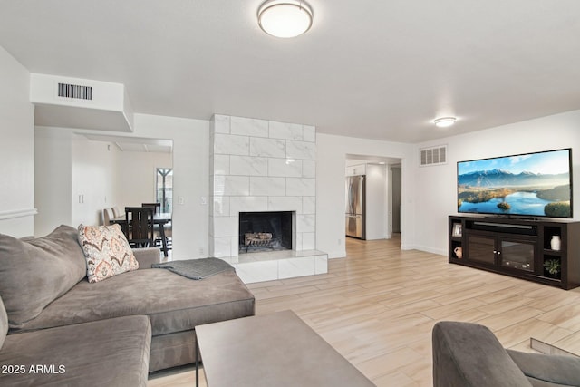 5119 E Shaw Butte Dr, Scottsdale, AZ 85254 - living area featuring light wood-type flooring, baseboards, and a tiled fireplace
