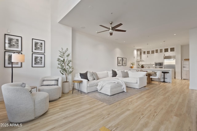 living room featuring light hardwood / wood-style flooring and ceiling fan