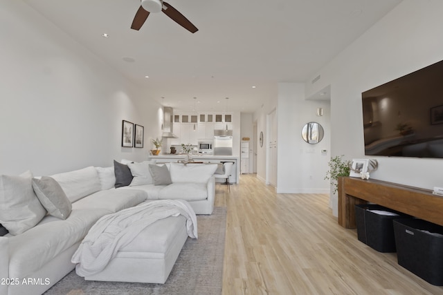 living room featuring ceiling fan and light wood-type flooring