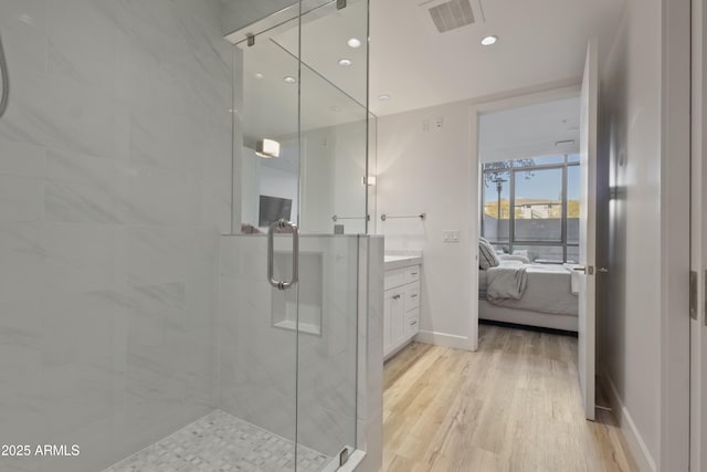 bathroom with an enclosed shower, hardwood / wood-style floors, and vanity