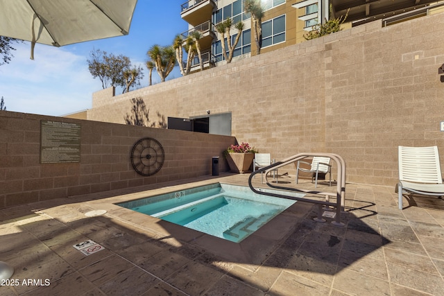 view of swimming pool with a patio area and a hot tub