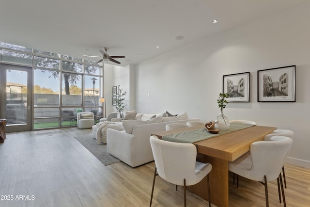 dining space featuring light hardwood / wood-style flooring, floor to ceiling windows, and ceiling fan