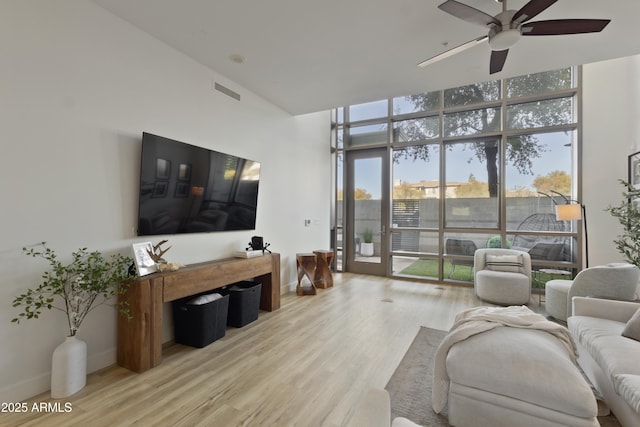 living room featuring floor to ceiling windows, ceiling fan, and light hardwood / wood-style flooring