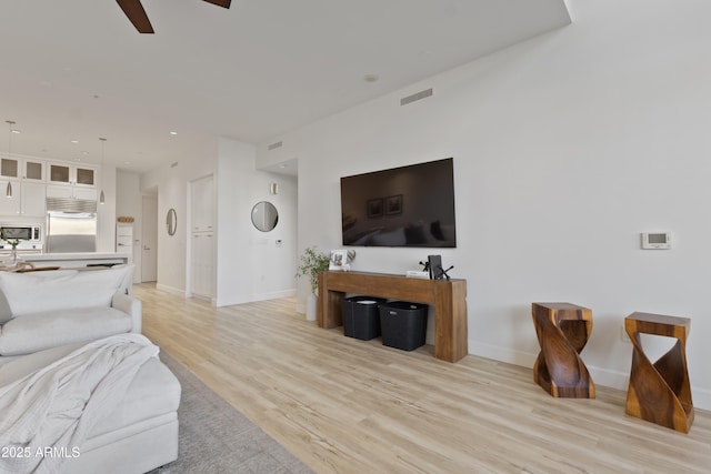 living room featuring ceiling fan and light wood-type flooring