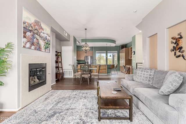 living room featuring dark hardwood / wood-style flooring and a tile fireplace