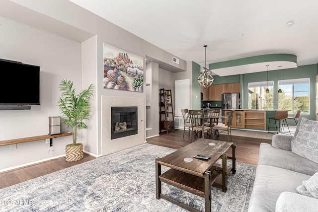 living room featuring a tiled fireplace and hardwood / wood-style flooring