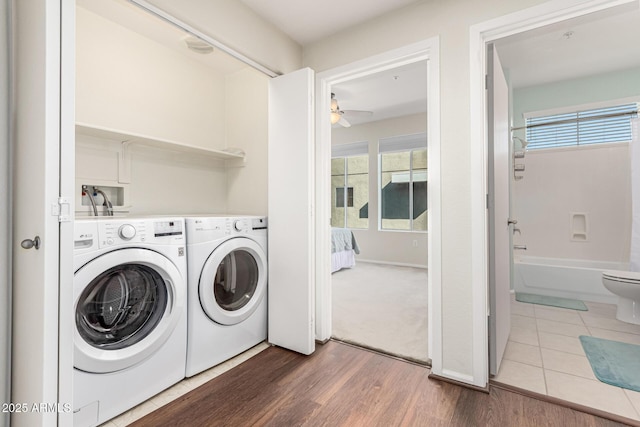 laundry area featuring ceiling fan, separate washer and dryer, and hardwood / wood-style floors