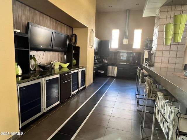 kitchen with dark tile patterned floors, dishwasher, and decorative backsplash