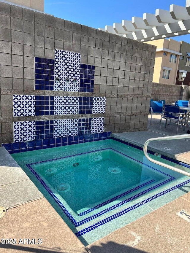 view of swimming pool featuring a hot tub