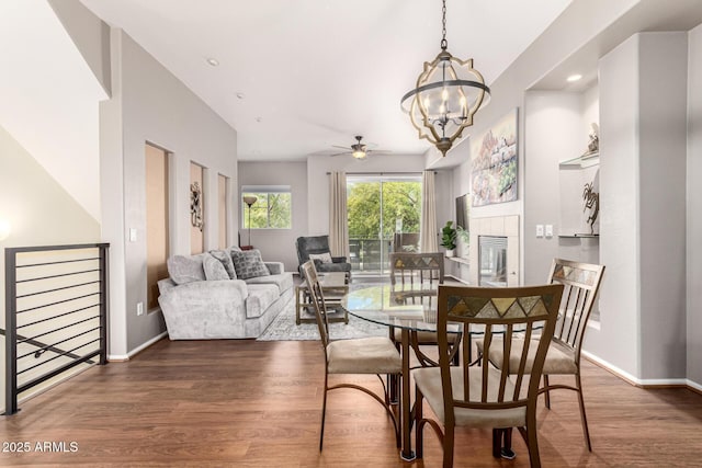 dining room featuring a tile fireplace, dark hardwood / wood-style floors, and a chandelier