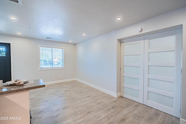 1135 E 4th St, Casa Grande, AZ 85122 - unfurnished living room featuring light wood finished floors, a textured ceiling, recessed lighting, and baseboards