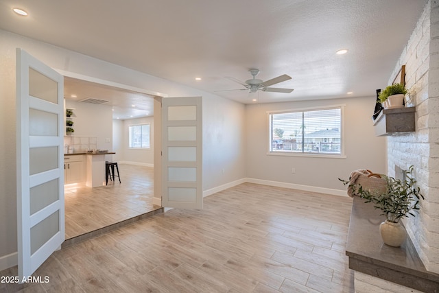 1135 E 4th St, Casa Grande, AZ 85122 - unfurnished living room featuring a ceiling fan, light wood-style floors, baseboards, recessed lighting, and a fireplace