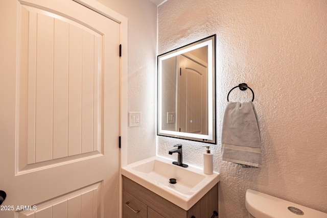 1135 E 4th St, Casa Grande, AZ 85122 - half bathroom with vanity, toilet, and a textured wall