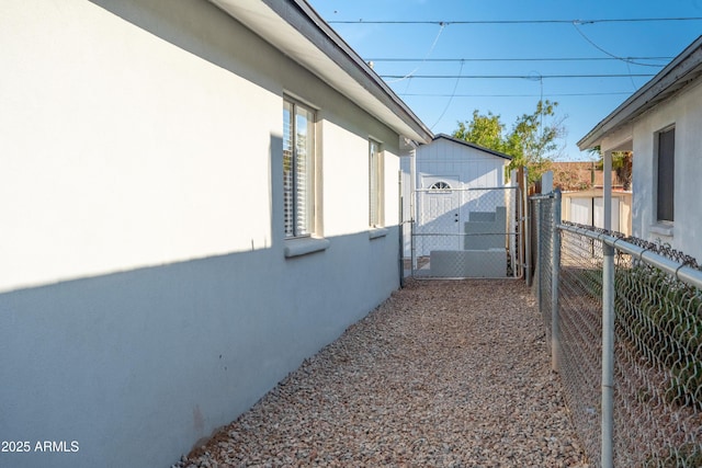 1135 E 4th St, Casa Grande, AZ 85122 - view of side of home featuring stucco siding and a gate