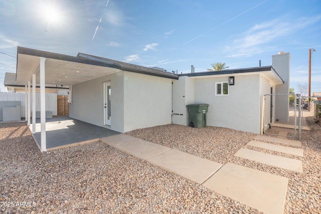 1135 E 4th St, Casa Grande, AZ 85122 - back of house with a gate, stucco siding, an attached carport, and a patio