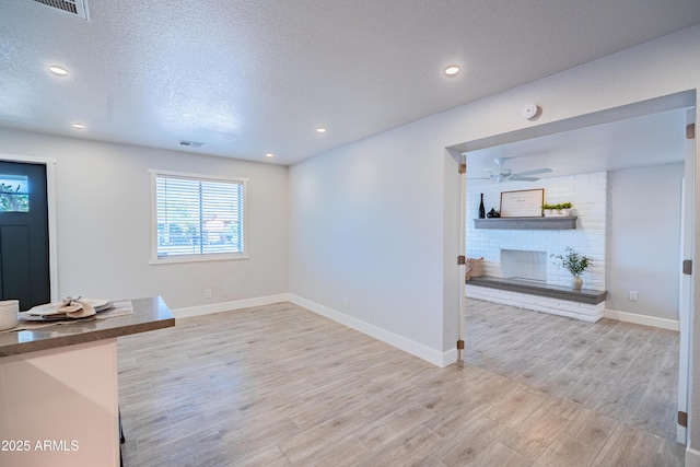 1135 E 4th St, Casa Grande, AZ 85122 - unfurnished living room featuring light wood-style floors, baseboards, a textured ceiling, ceiling fan, and recessed lighting