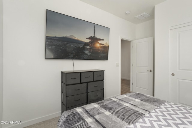 bedroom with light carpet, visible vents, and baseboards