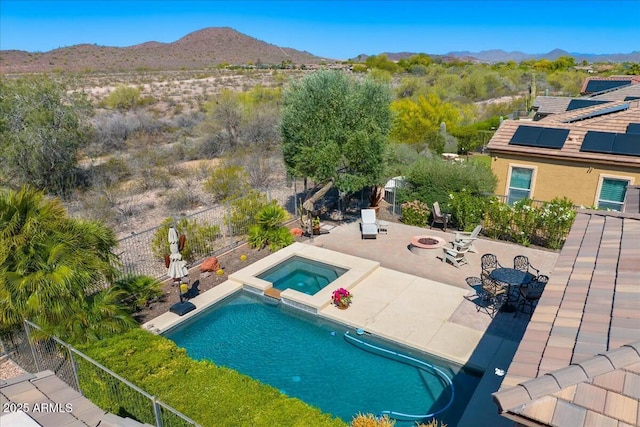view of pool with a pool with connected hot tub, a fenced backyard, a patio, a fire pit, and a mountain view