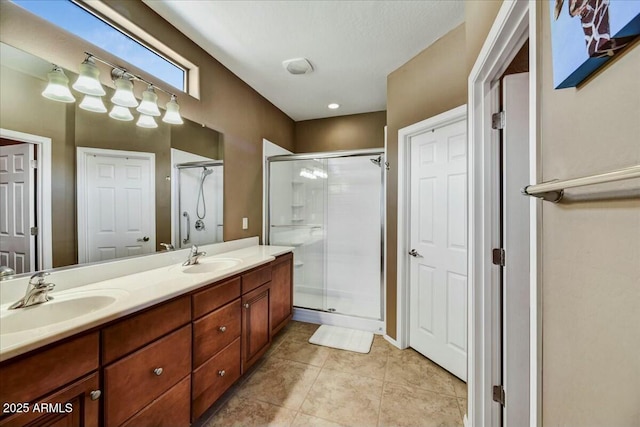 full bathroom featuring a shower stall, double vanity, and a sink