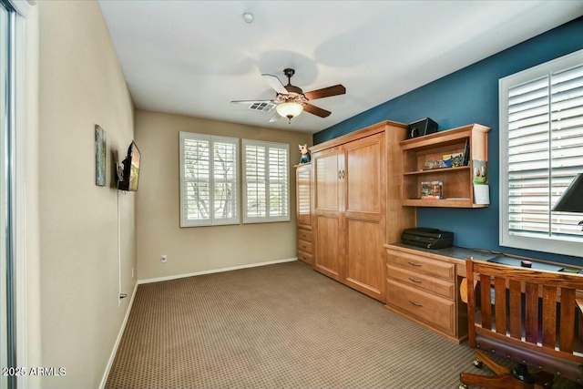 bedroom featuring a closet, built in study area, light colored carpet, and baseboards