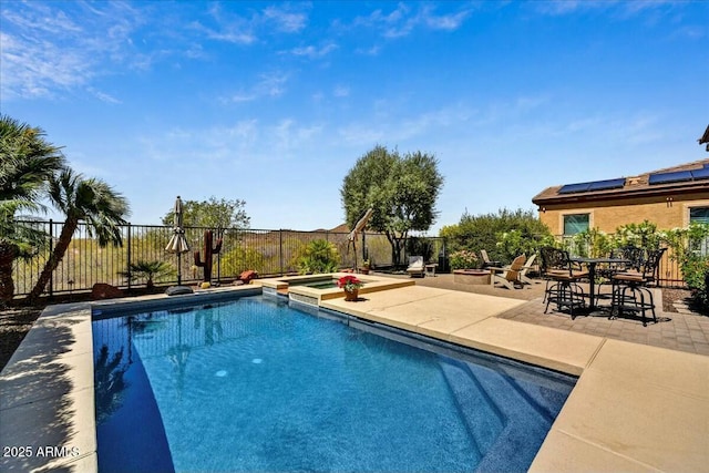 view of swimming pool featuring a patio area, a pool with connected hot tub, and fence