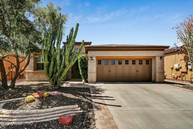 view of front of house with a tiled roof, an attached garage, stucco siding, and concrete driveway