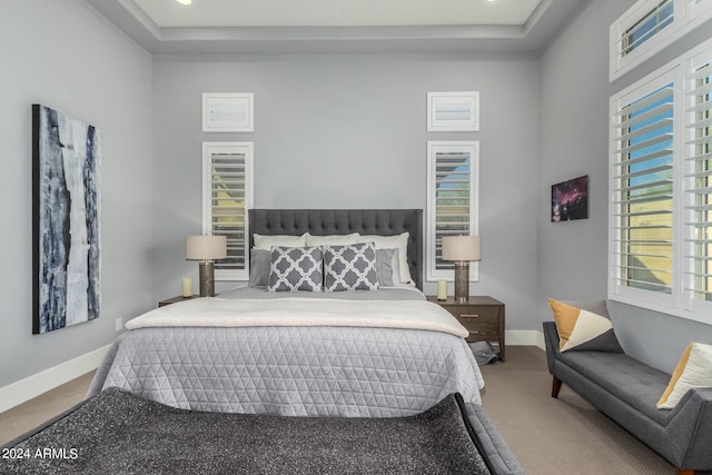 carpeted bedroom featuring a tray ceiling, recessed lighting, a towering ceiling, and baseboards