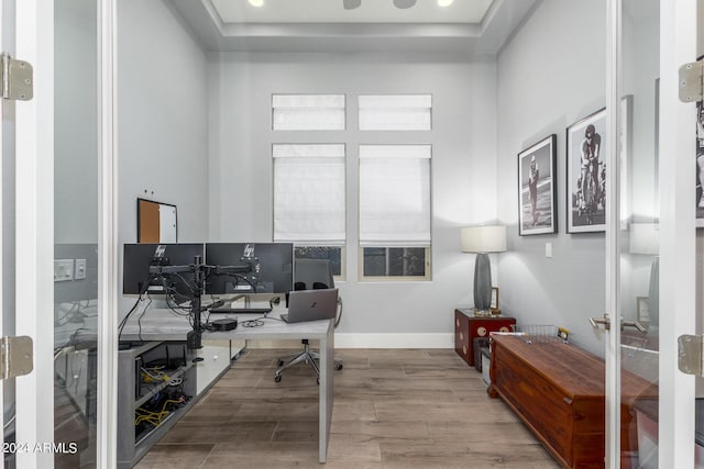 office space featuring a raised ceiling, french doors, wood finished floors, and baseboards