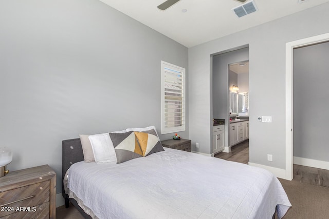 bedroom featuring baseboards, visible vents, connected bathroom, and wood finished floors