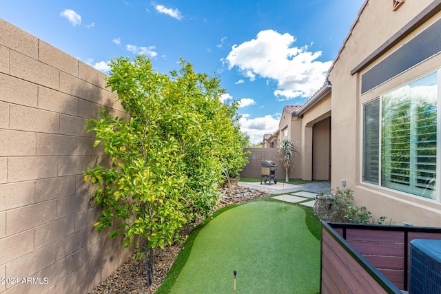 view of yard with central AC unit, a patio area, and a fenced backyard