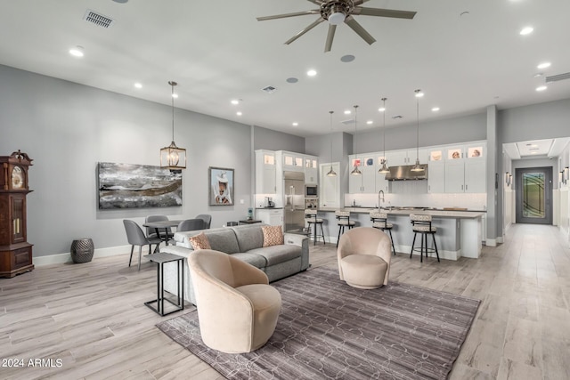 living room with ceiling fan, recessed lighting, visible vents, baseboards, and light wood finished floors