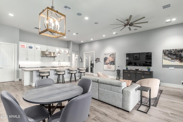 living room featuring light wood-style floors, visible vents, and recessed lighting